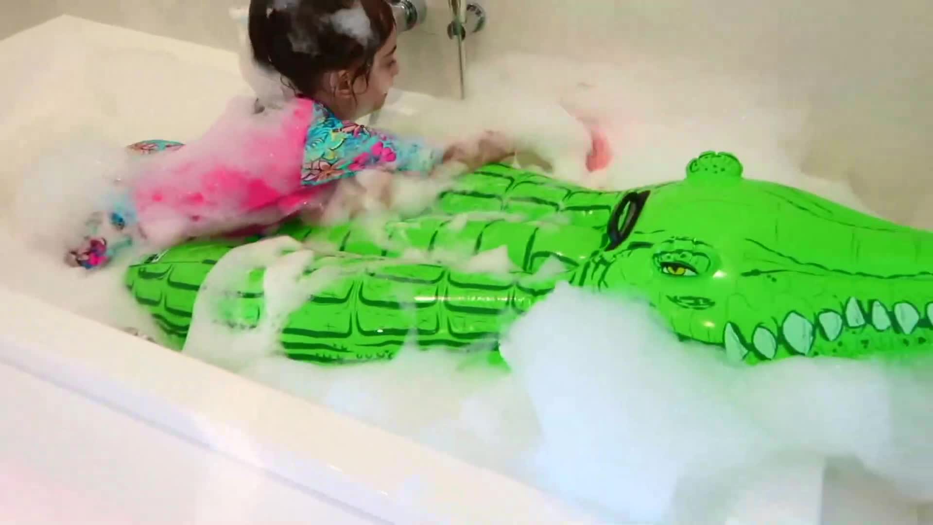 Watch this little one’s happy bath adventure! 🥰 Covered in fluffy bubbles, she’s playing and splashing with her green inflatable crocodile toy 🐊. So much giggles and fun—perfect for a cozy, playful moment! 😊 #BathTimeMagic #KidsPlay