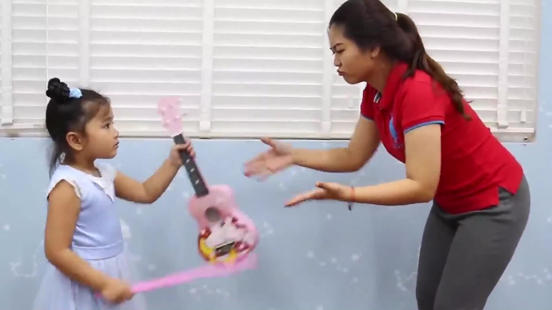 A sweet moment as a little girl plays her cute pink toy guitar, interacting happily with her teacher! Theyโre having fun making music, sharing smiles, and enjoying a joyful playtime together. ๐ถโจ Itโs all about laughter, learning, and sweet connections! ๐