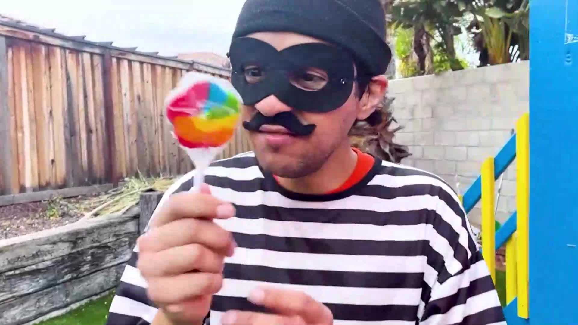Watch the silly Candy Bandit (in a classic black-and-white stripe shirt and mask!) try to finish this huge, colorful rainbow lollipop in the backyard! 🌈 With a funny mustache and playful energy, it’s a sweet, kid-friendly adventure full of giggles and delicious candy fun! 😋