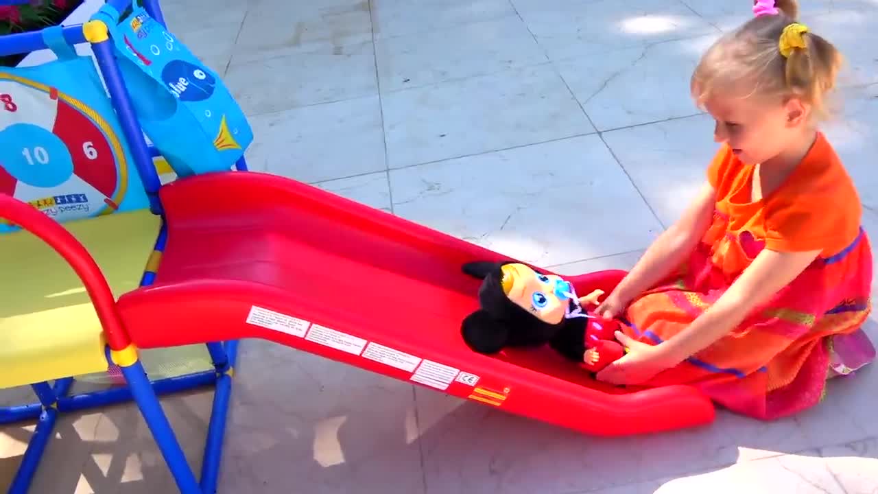 Watch this sweet little girl have fun playing with her cute doll on the colorful slide! She gently pushes the doll down the slide, giggling and enjoying every moment of their playful adventure. A heartwarming scene of imagination and joy! 😊