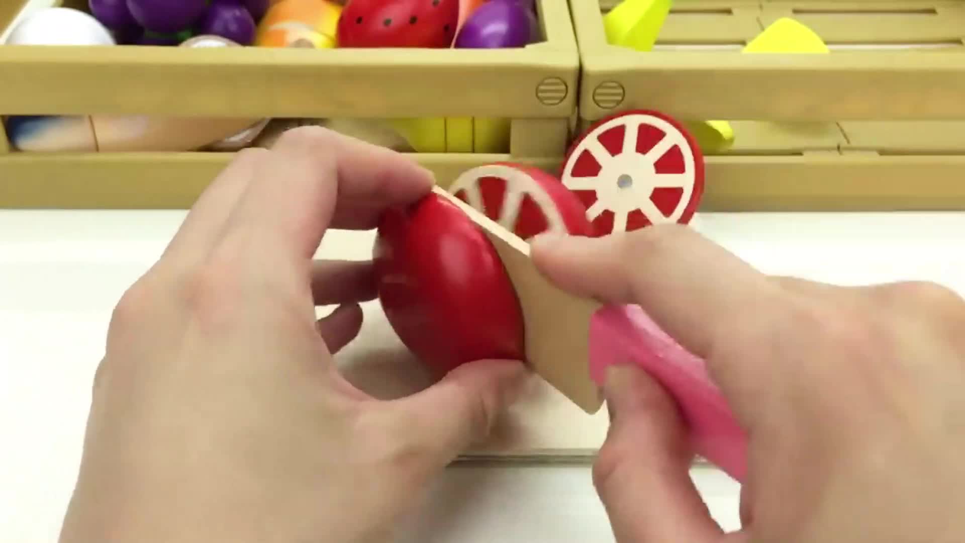 Watch as we cut this cute red fruit toy with a toy knife! 🔍 It's a fun wooden play food set—great for little chefs! 👩🍳 There are colorful fruits and shapes in the background too! 🎈 Kids will love exploring and playing with this! 🧸