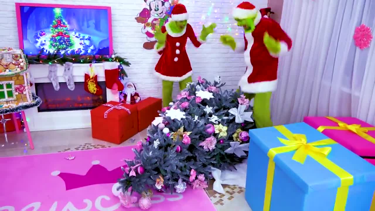 A playful Christmas scene with two green Grinch characters in red Santa suits! They're dancing, decorating, and having fun near a sparkly Christmas tree, surrounded by colorful presents, a cozy fireplace, and cute holiday decor. It's full of Christmas magic and silly mischief—perfect for little ones! 🎅🤶