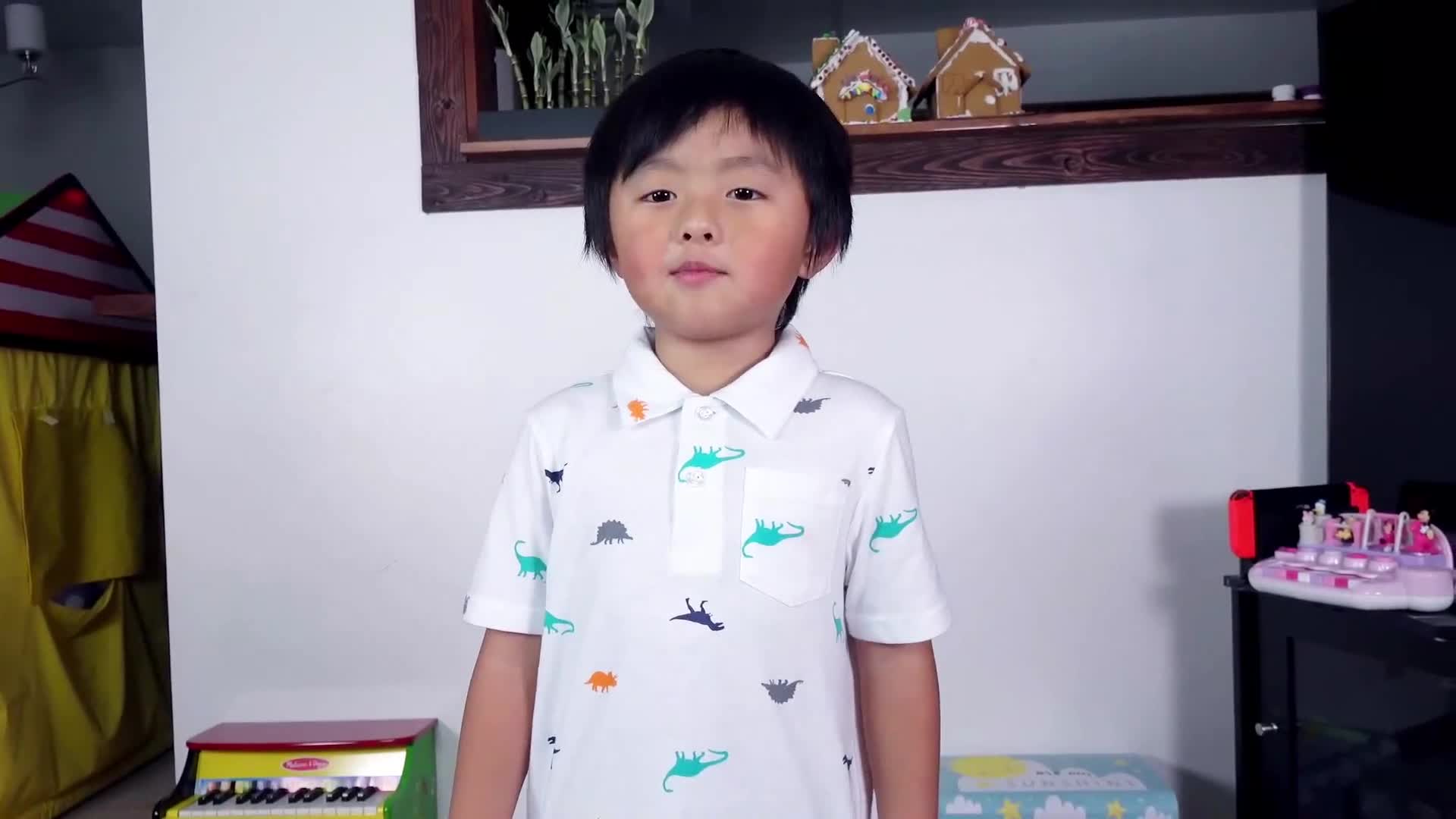 A cheerful young boy stands proudly in his colorful playroom, wearing a fun dino-themed shirt ๐ฆ! Behind him, there are playful toys like a mini piano ๐น, a cozy play tent ๐๏ธ, and adorable gingerbread houses ๐ on the shelf. Itโs a happy, lively space full of joy! ๐