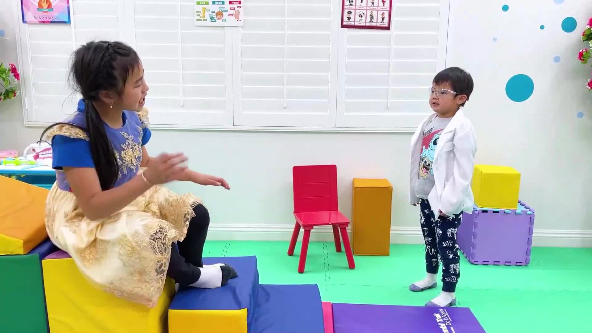 In a bright, colorful playroom, two little friends are playing doctor! The girl sits on soft foam blocks, chatting and smiling, while the boy in a white coat (our tiny 'doctor') listens carefully. They're having a joyful, imaginative timeโfull of giggles and friendly interaction, just like real little healers! ๐ฅฐ